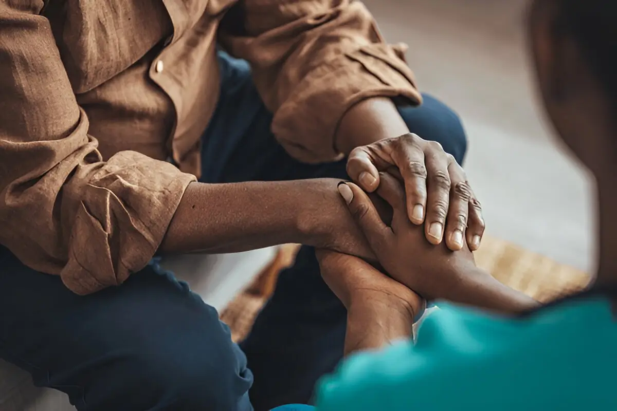 A man and woman holding hands together in reassurance.