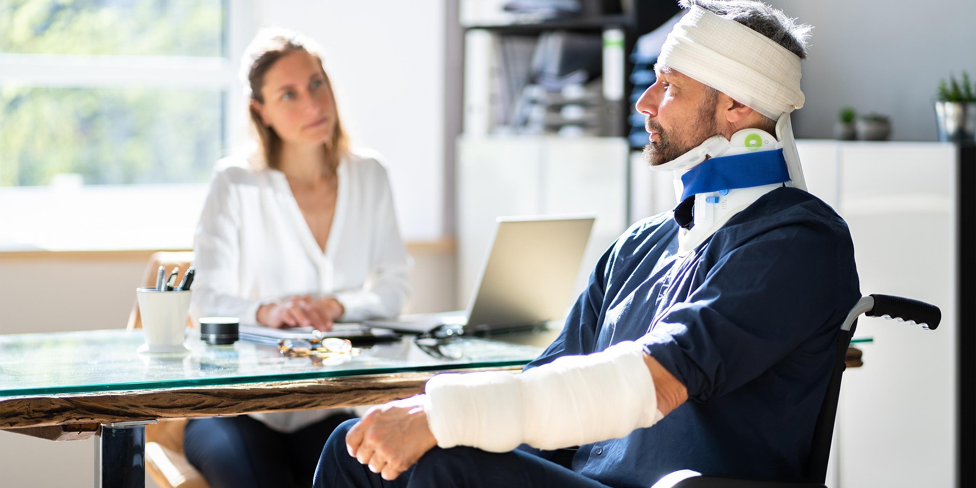 A disabled person in a doctor's office, with the female doctor asking him some questions.