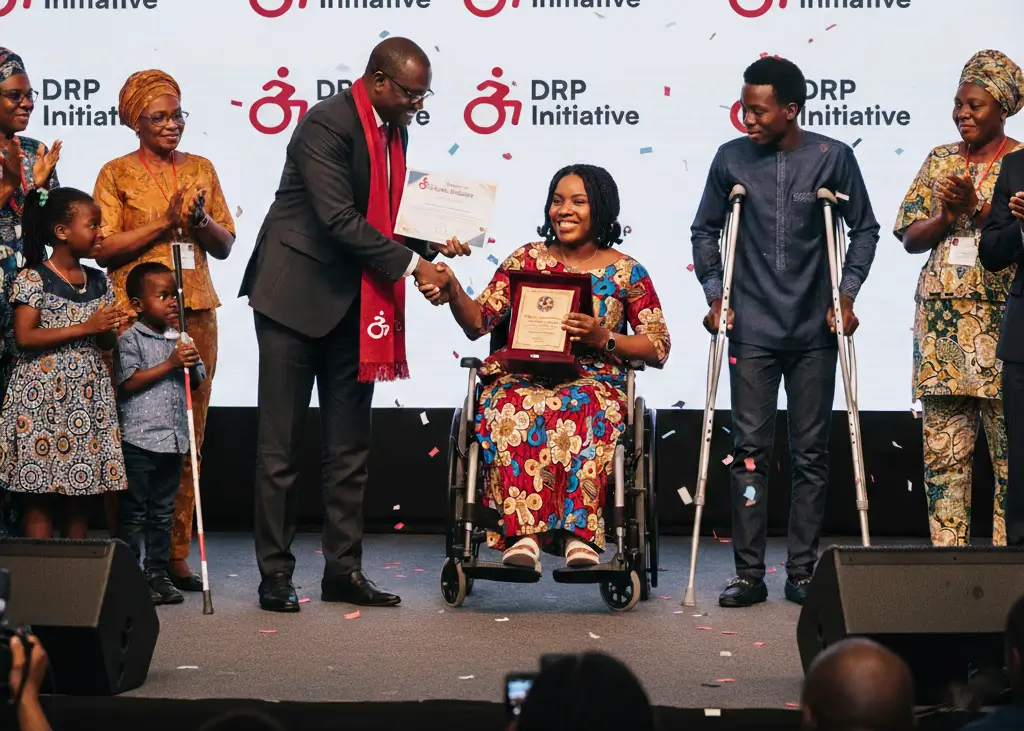 A woman on wheelchair, with other disabled persons by her sides, recieving an award at a DRP Initivative event.