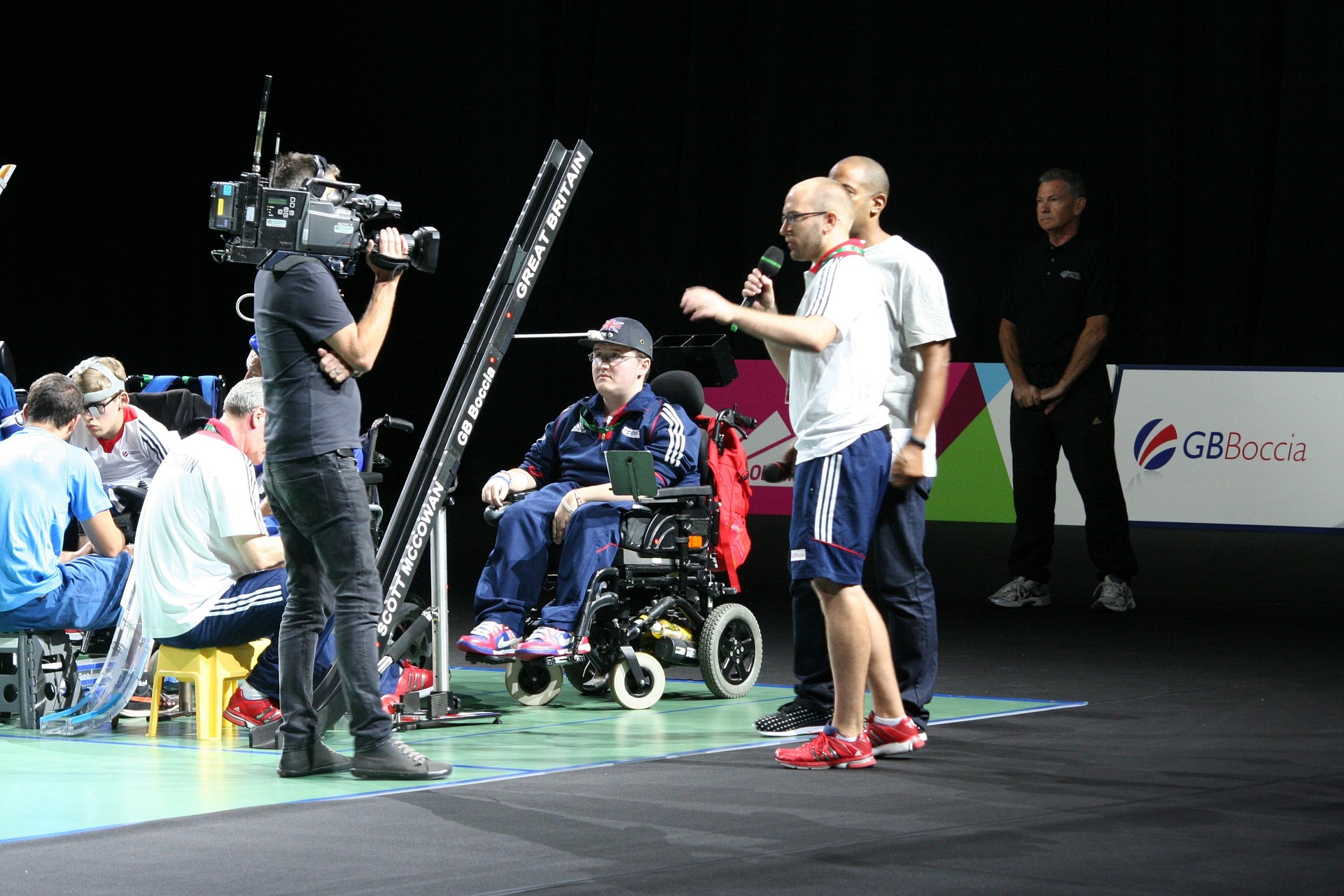 Some disabled people gathered at a paralympic event, at night.