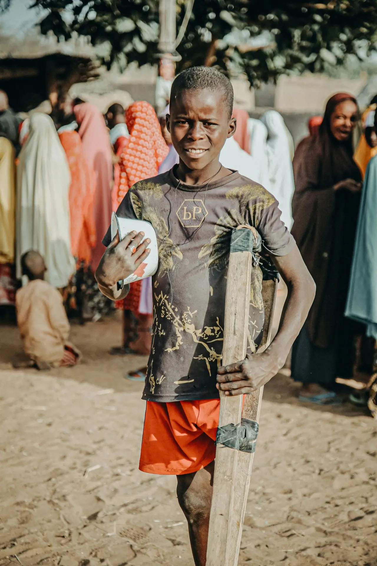 A teeneger in crutches, holding a bowl in one hand.